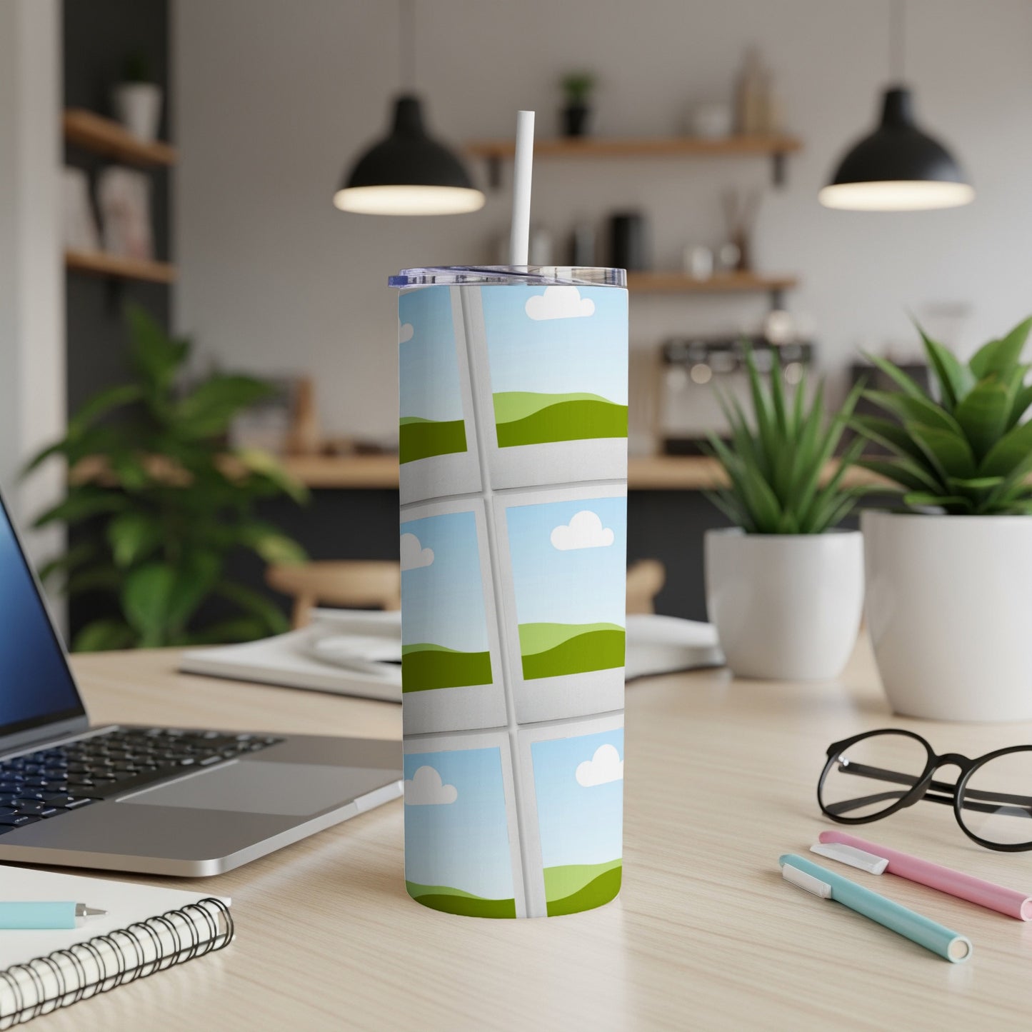 Tumbler with a sky and rolling hills graphic and a white straw.