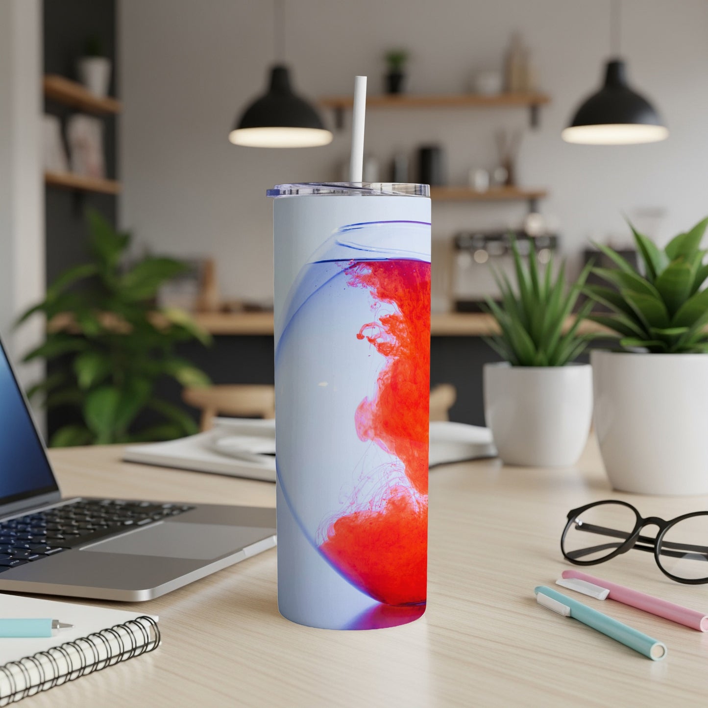 Tumbler with swirling red and blue liquid and a white straw.