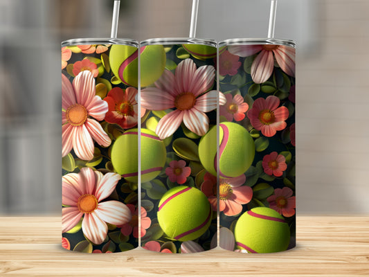 Tumbler with tennis balls and pink flowers against dark floral background.
