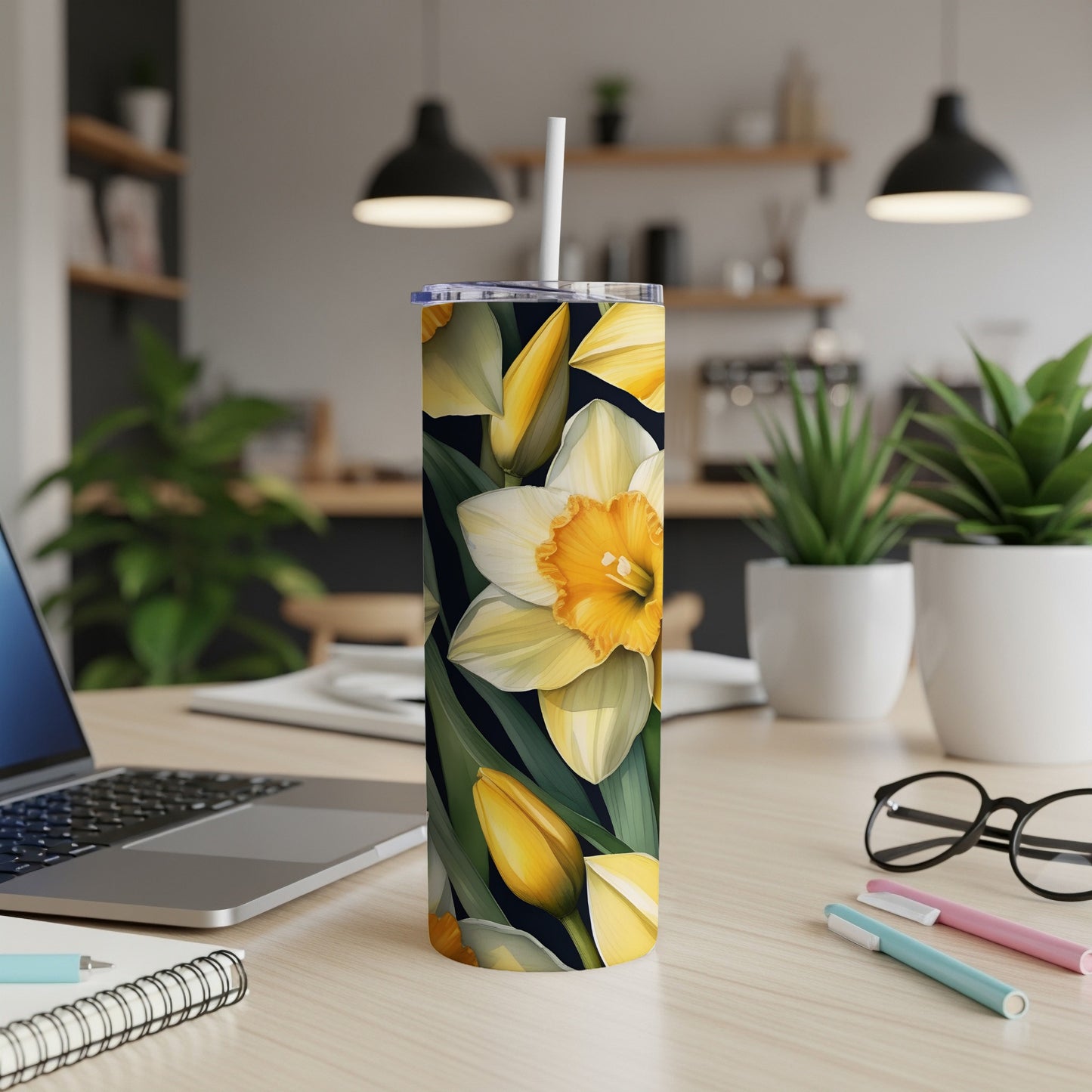 Tall tumbler with a floral pattern of yellow and white daffodils on a dark background.