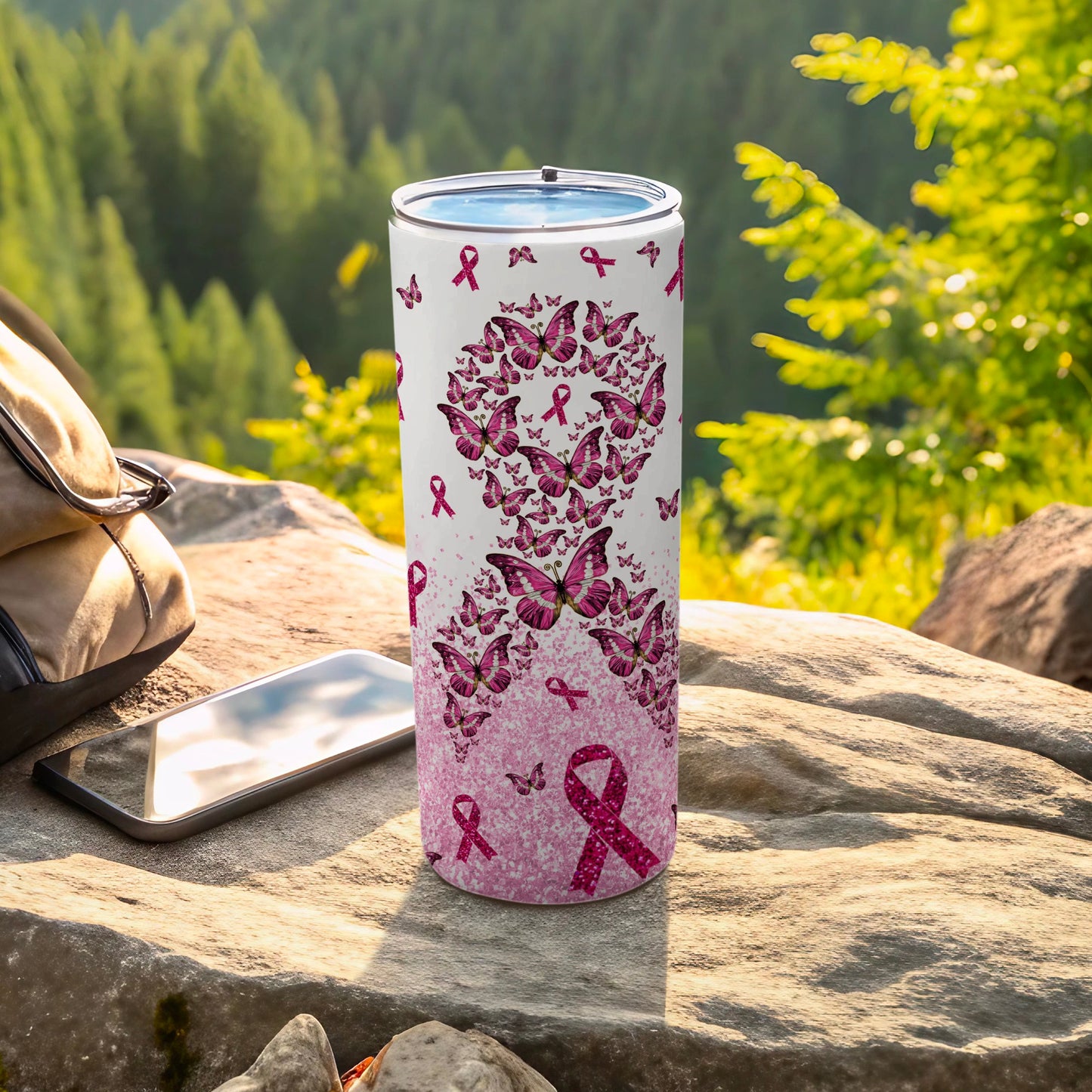 Pink butterfly and ribbon design on a white tumbler with a phone and backpack.