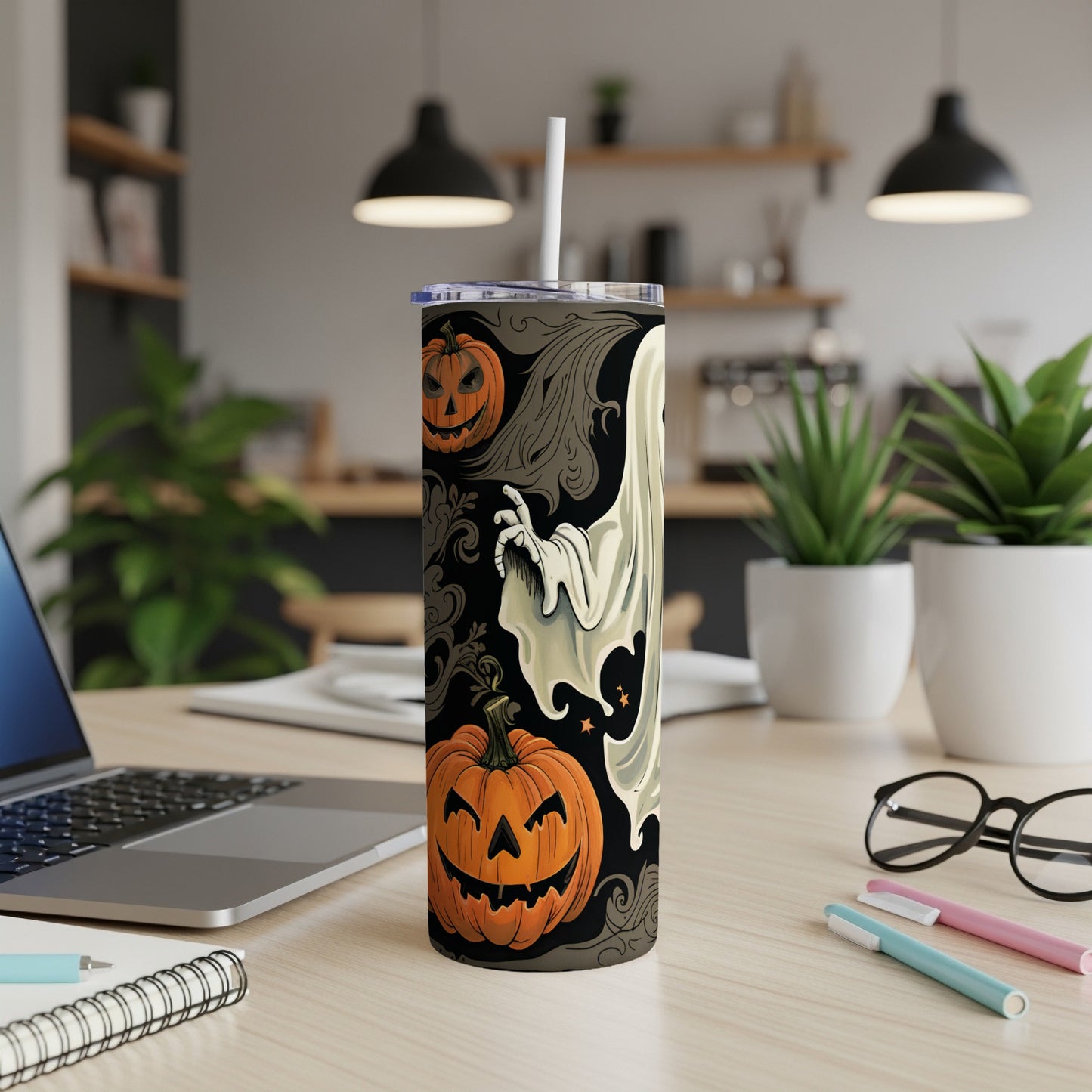 Tall tumbler with Halloween ghost and pumpkin design, featuring a straw.