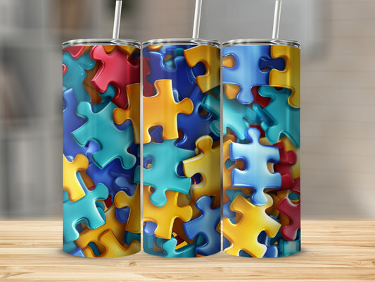 Three tumblers decorated with colorful puzzle pieces on a wooden surface.