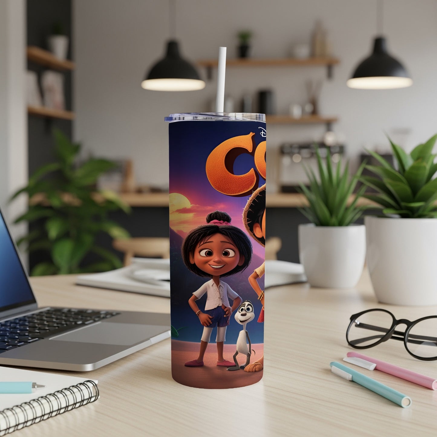 Cartoon girl and dog on a colorful tumbler next to a laptop.