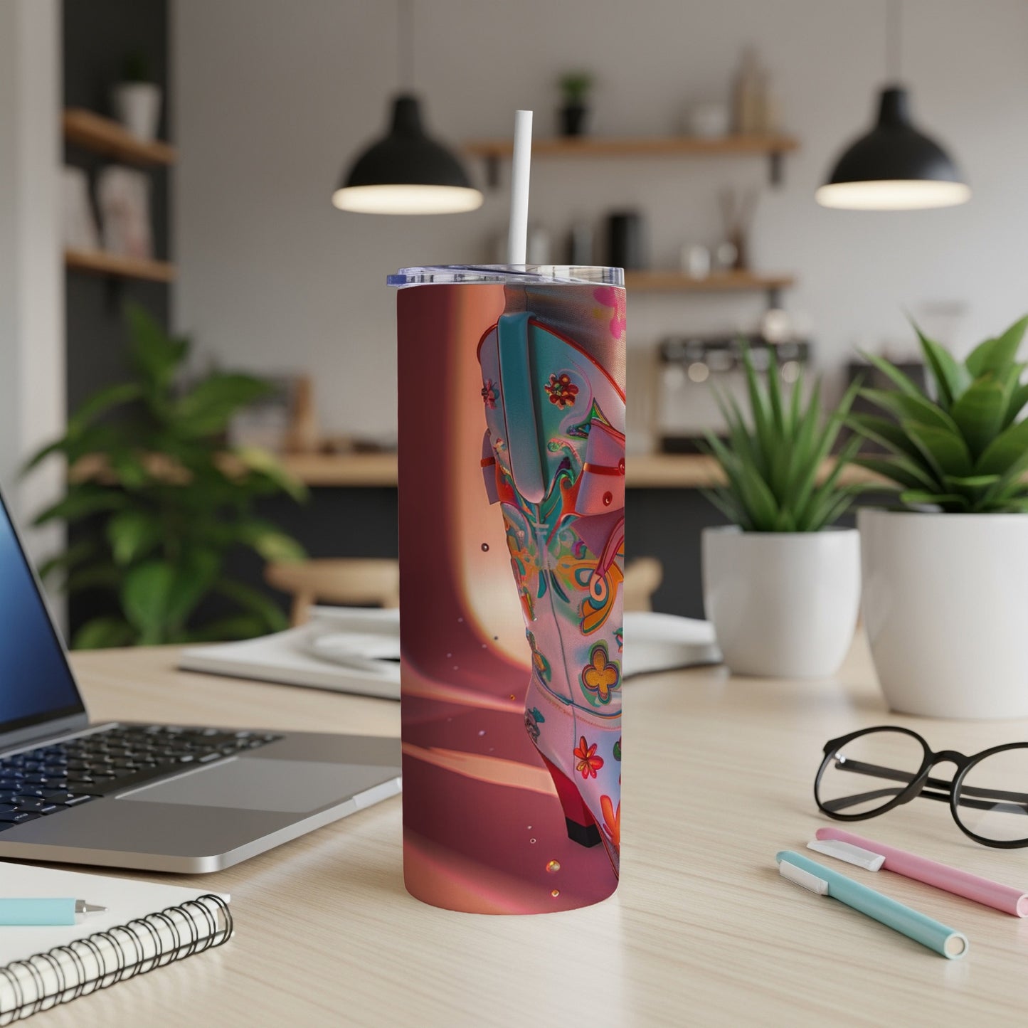 Pink and blue patterned cowboy boot on a tumbler with straw.