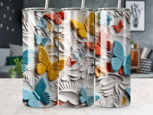 Three tumblers with embossed butterflies in various colors against a white floral background.