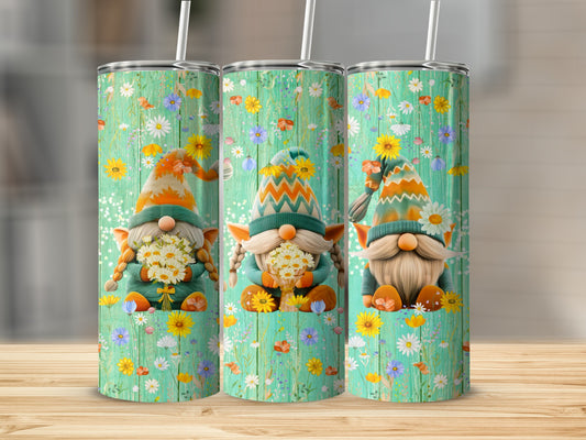 Three gnomes with flowers on a floral patterned tumbler.