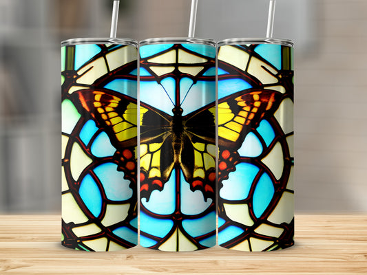 Butterfly stained glass tumbler with straws on a wooden surface.