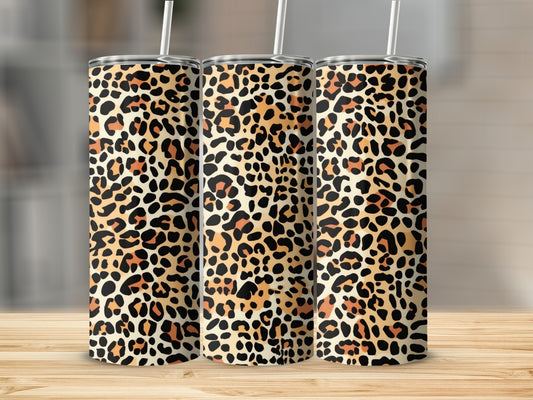 Three tumblers with a leopard print pattern sit on a wooden surface.