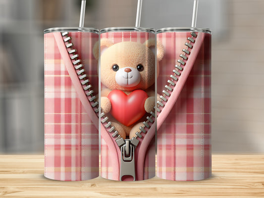 Teddy bear with heart peeking through a zipper on a pink plaid tumbler.
