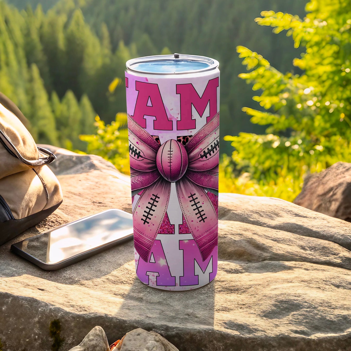 Pink football tumbler with bow design and "I AM" text.