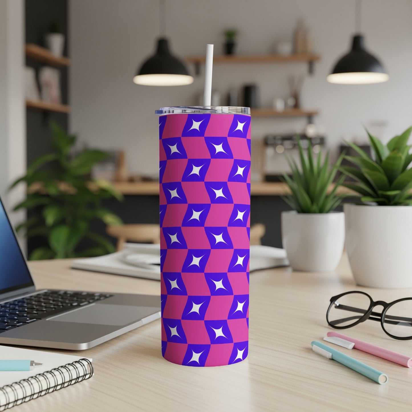Purple and blue geometric tumbler with straw on a desk.