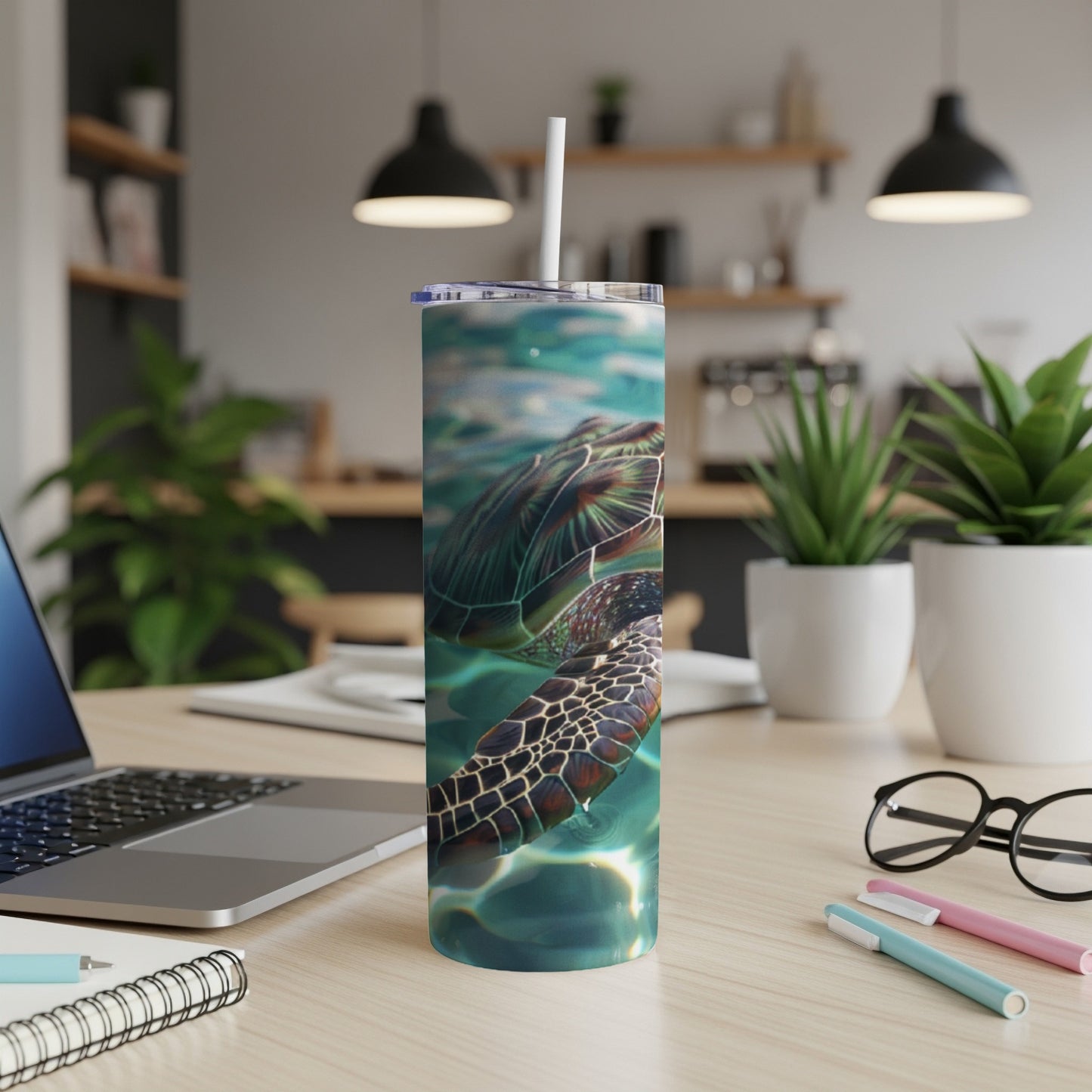 Sea turtle swimming underwater on a stainless steel tumbler with straw.