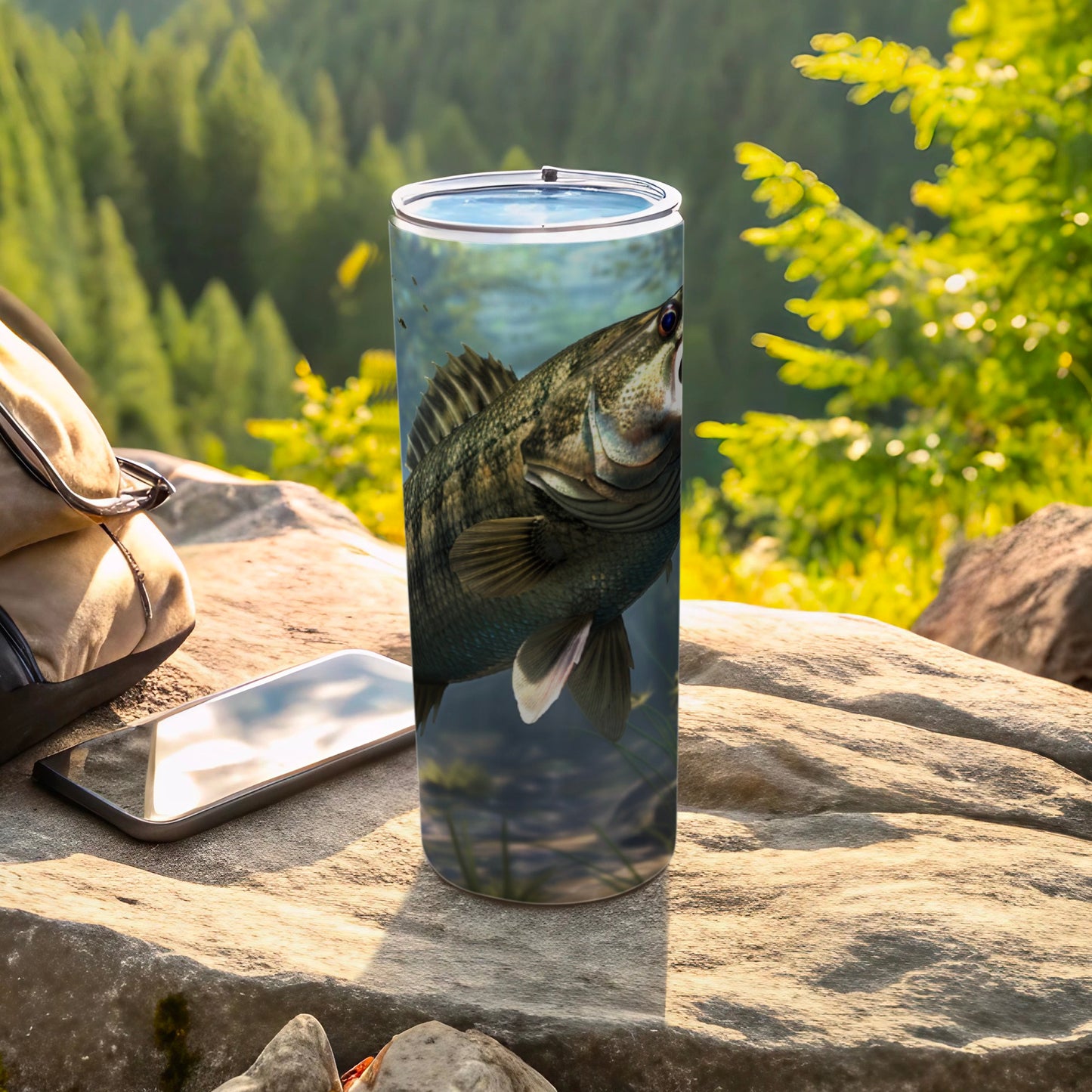 Black bass fish on a tumbler next to a phone and backpack.