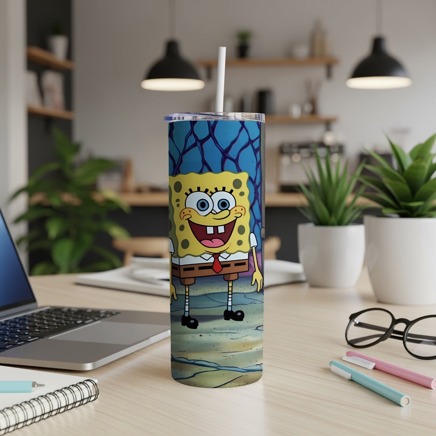SpongeBob SquarePants tumbler with lid and straw on a desk.