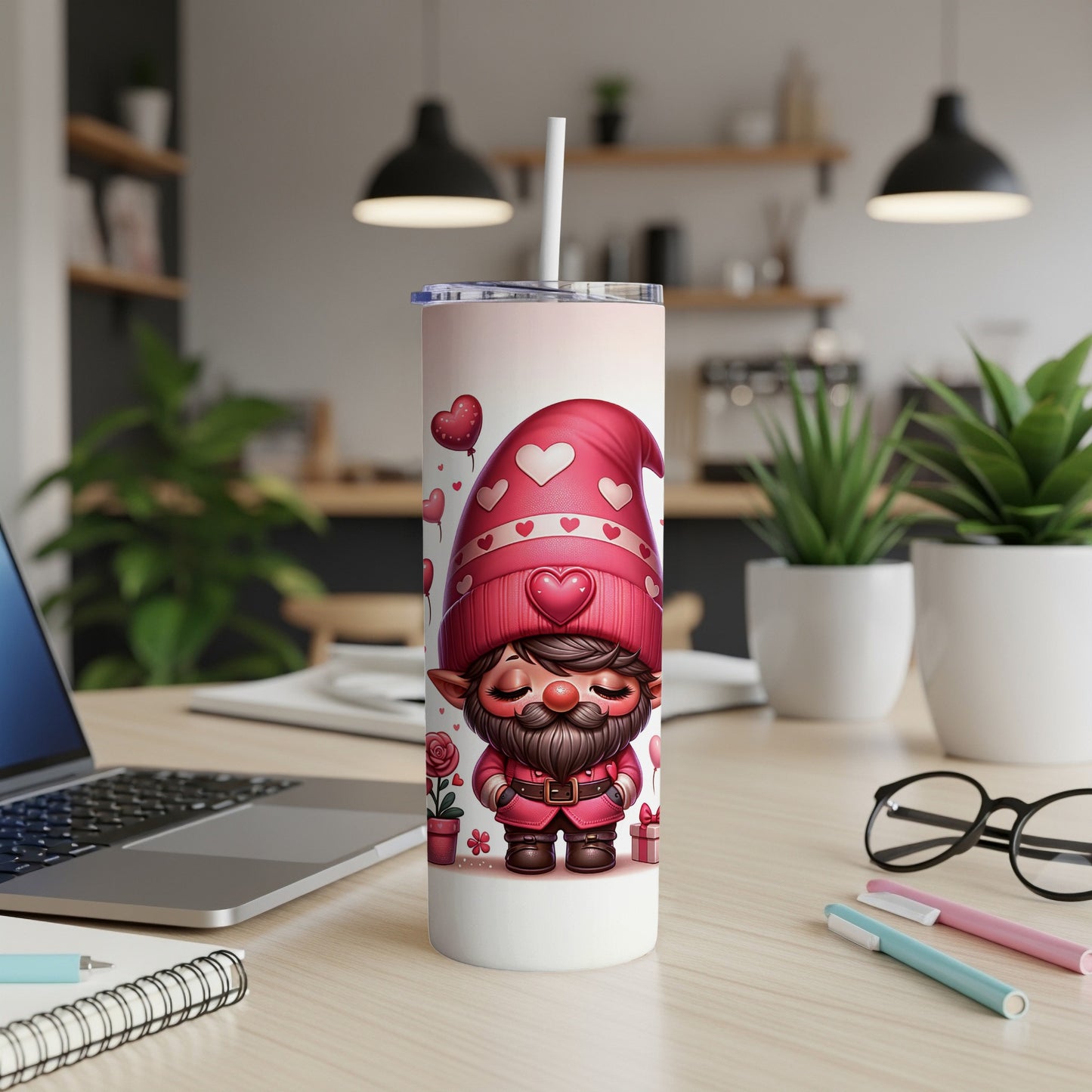 Valentine's Day gnome tumbler with hearts and a straw, on a desk.