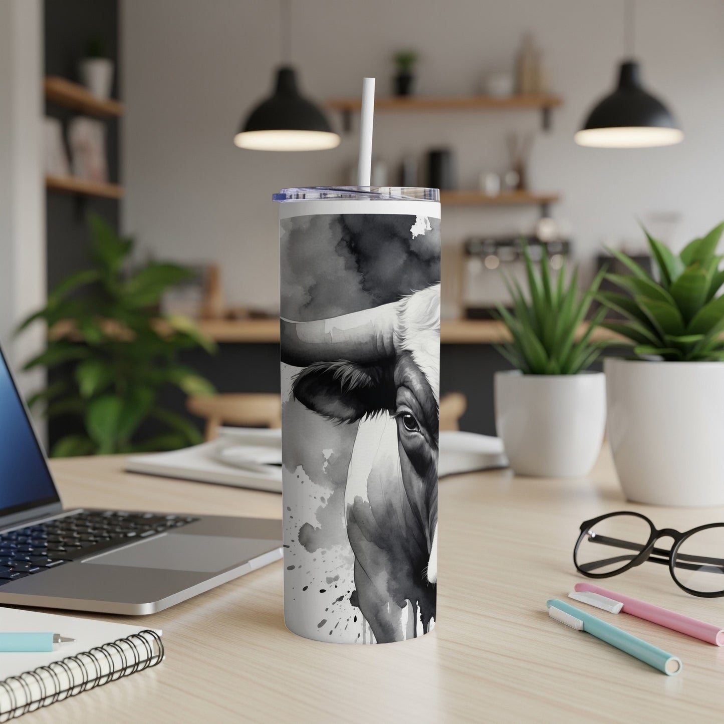 Black and white watercolor cow pattern on a tall tumbler with straw.