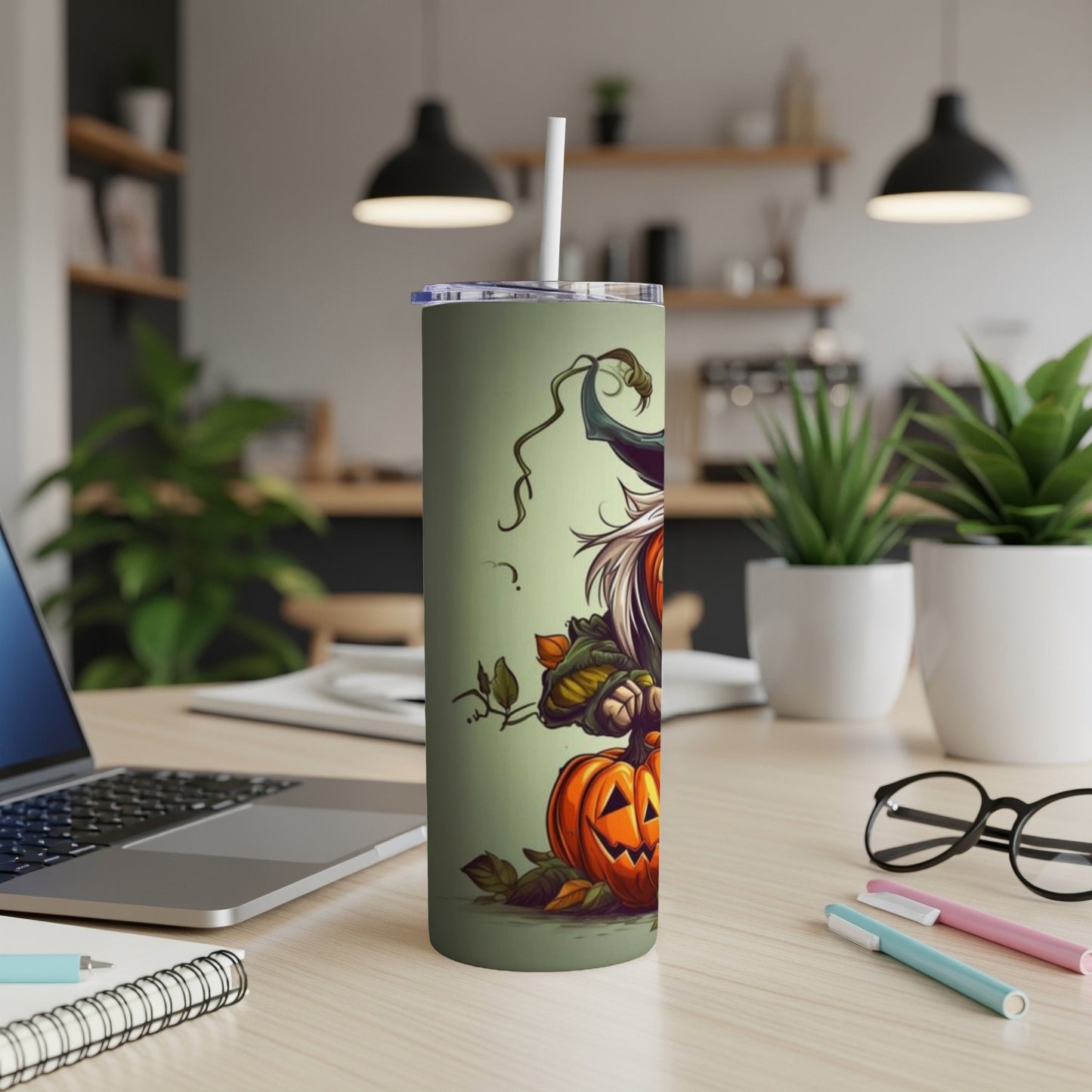 Green tumbler with cartoon witch and pumpkin design, with straw.