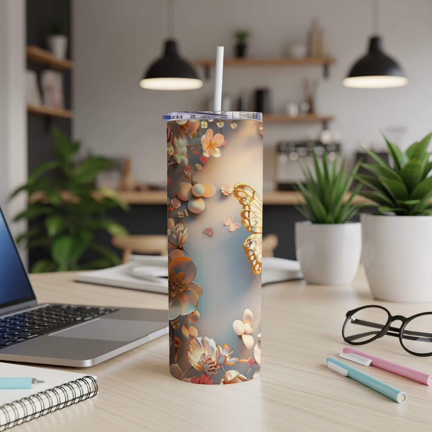 Floral butterfly tumbler with white straw on a desk.