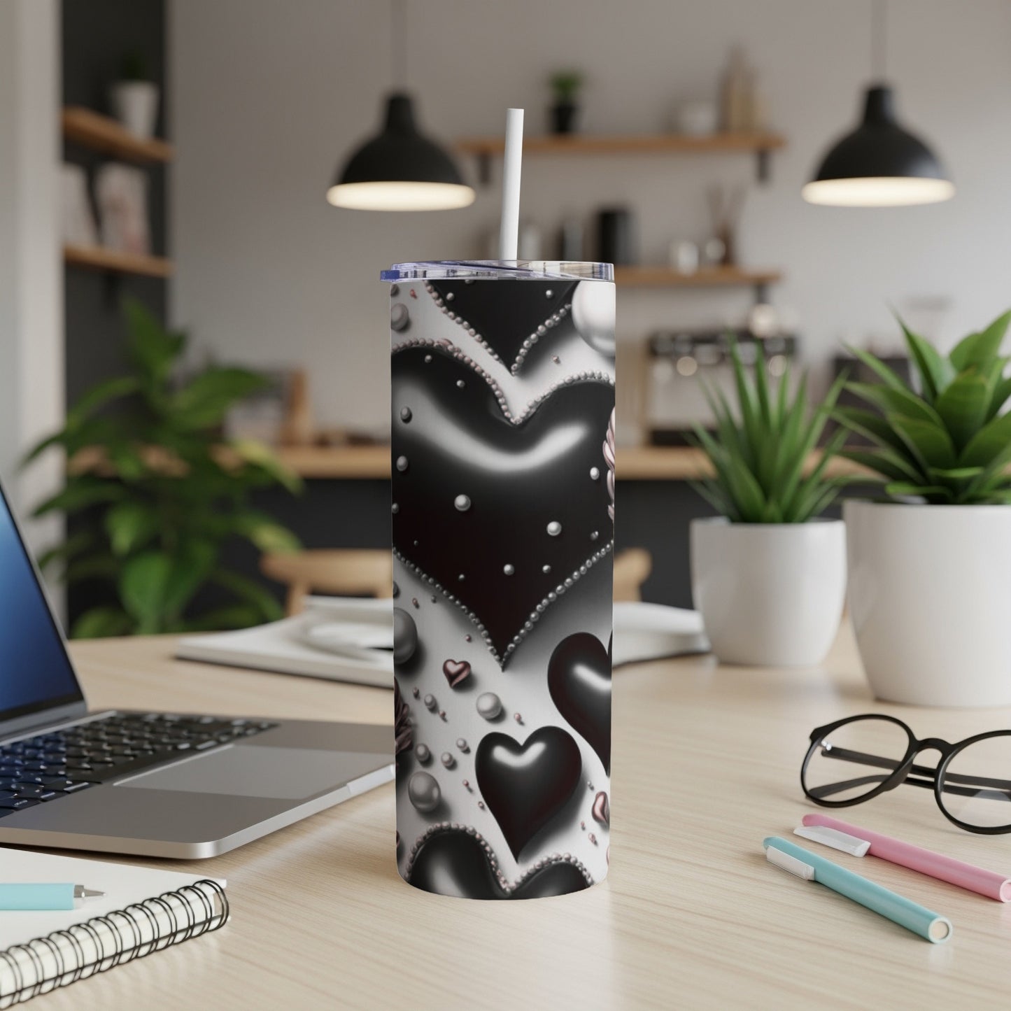 Black and white hearts pattern on a white skinny tumbler with a straw.