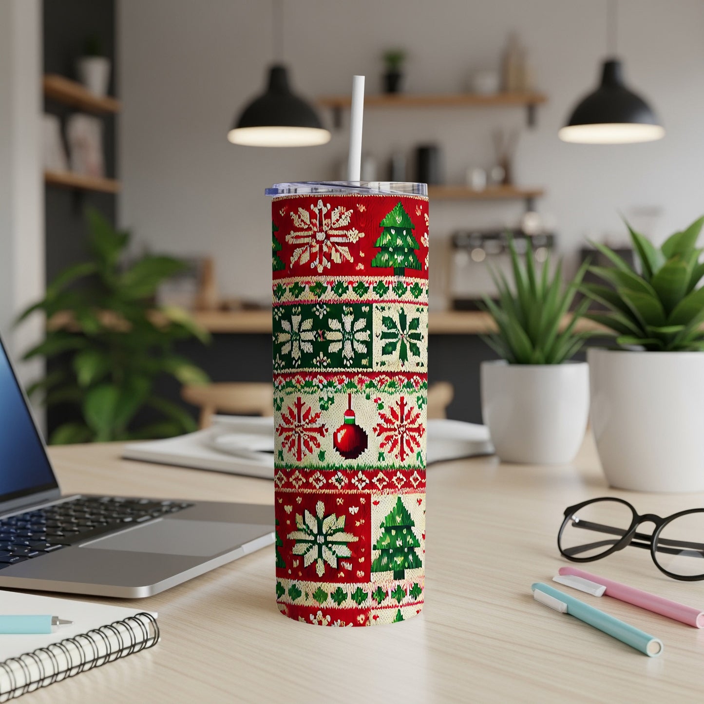 Red and green knitted Christmas tumbler with snowflakes, trees, and ornaments.