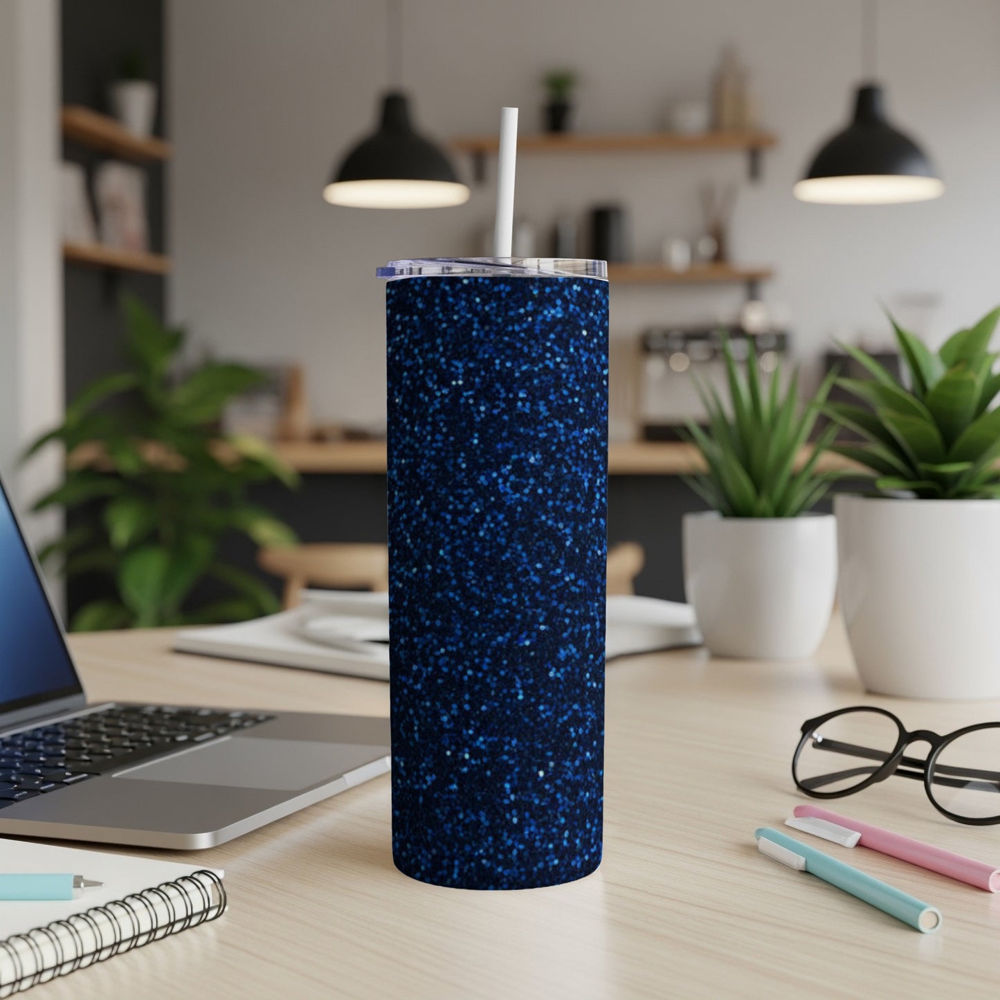 Blue glitter tumbler with white straw on a desk.