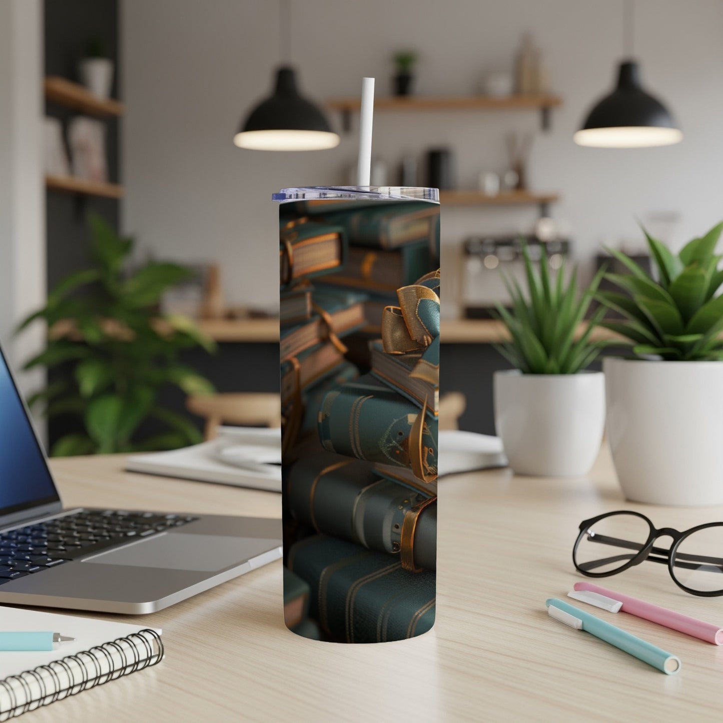 Stack of antique books with gold accents on a desk next to a laptop.