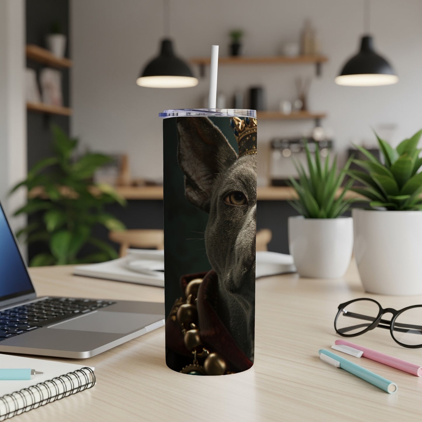 Gray dog wearing a crown and ornate collar on a tumbler.
