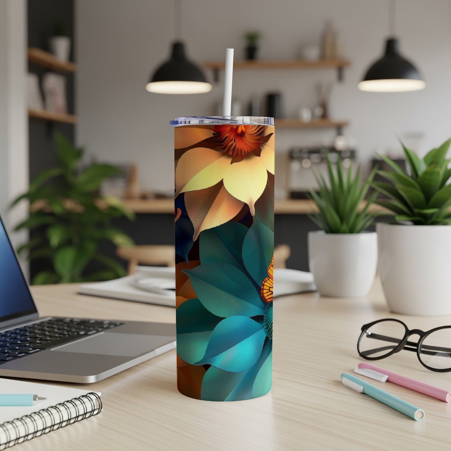 Tall tumbler with vibrant floral pattern and straw, on a desk.