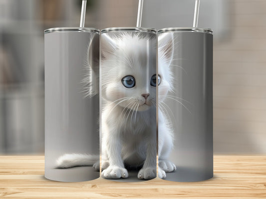 White kitten with bright blue eyes sits between two white tumblers.