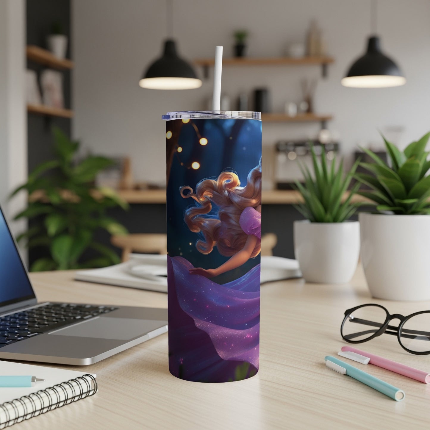 Purple tumbler with fairy illustration and straw, on a desk.