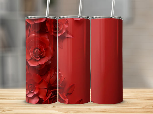Three red tumblers with floral designs on a wooden surface.