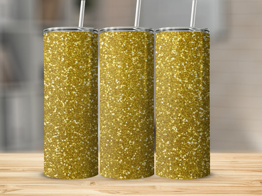 Three golden glitter tumblers with straws on a wooden surface.