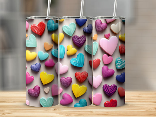 Three tumblers adorned with colorful, textured heart patterns.
