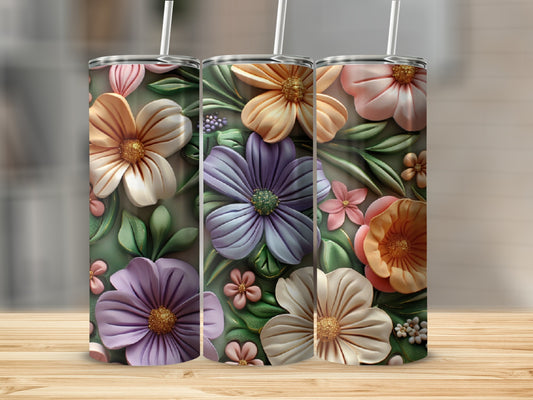 Three floral-patterned tumblers with purple, orange, and pink flowers on a wooden surface.