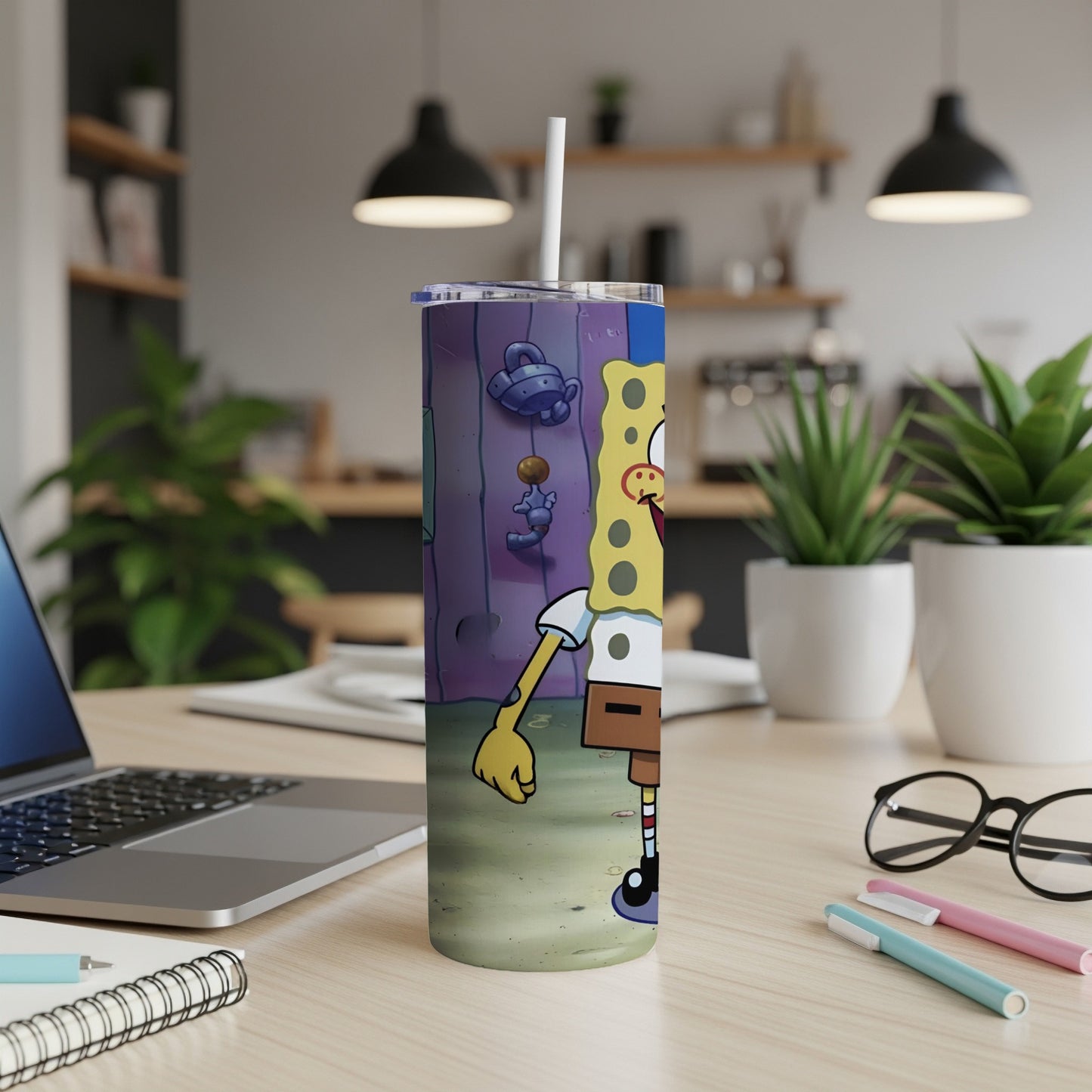 SpongeBob SquarePants tumbler with lid and straw on a desk.