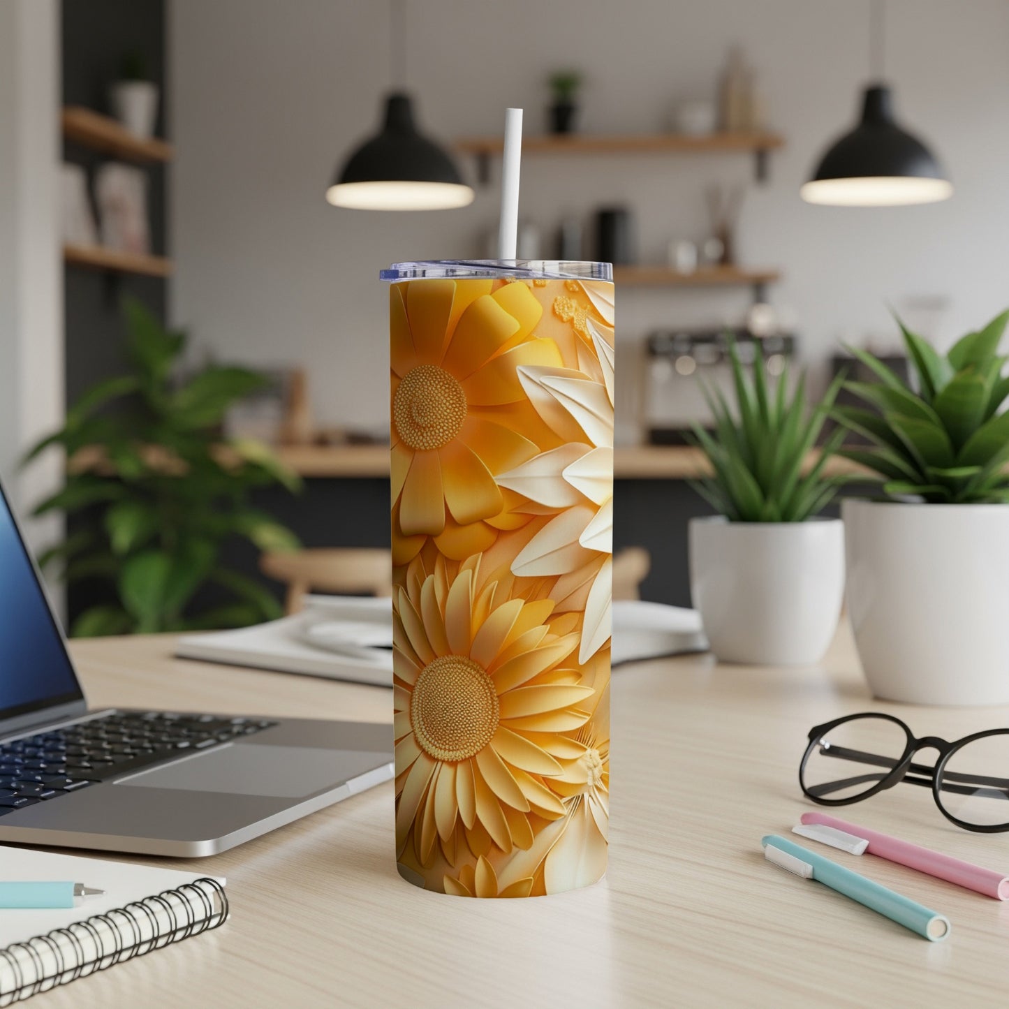 Yellow floral print tumbler with white straw on a desk.