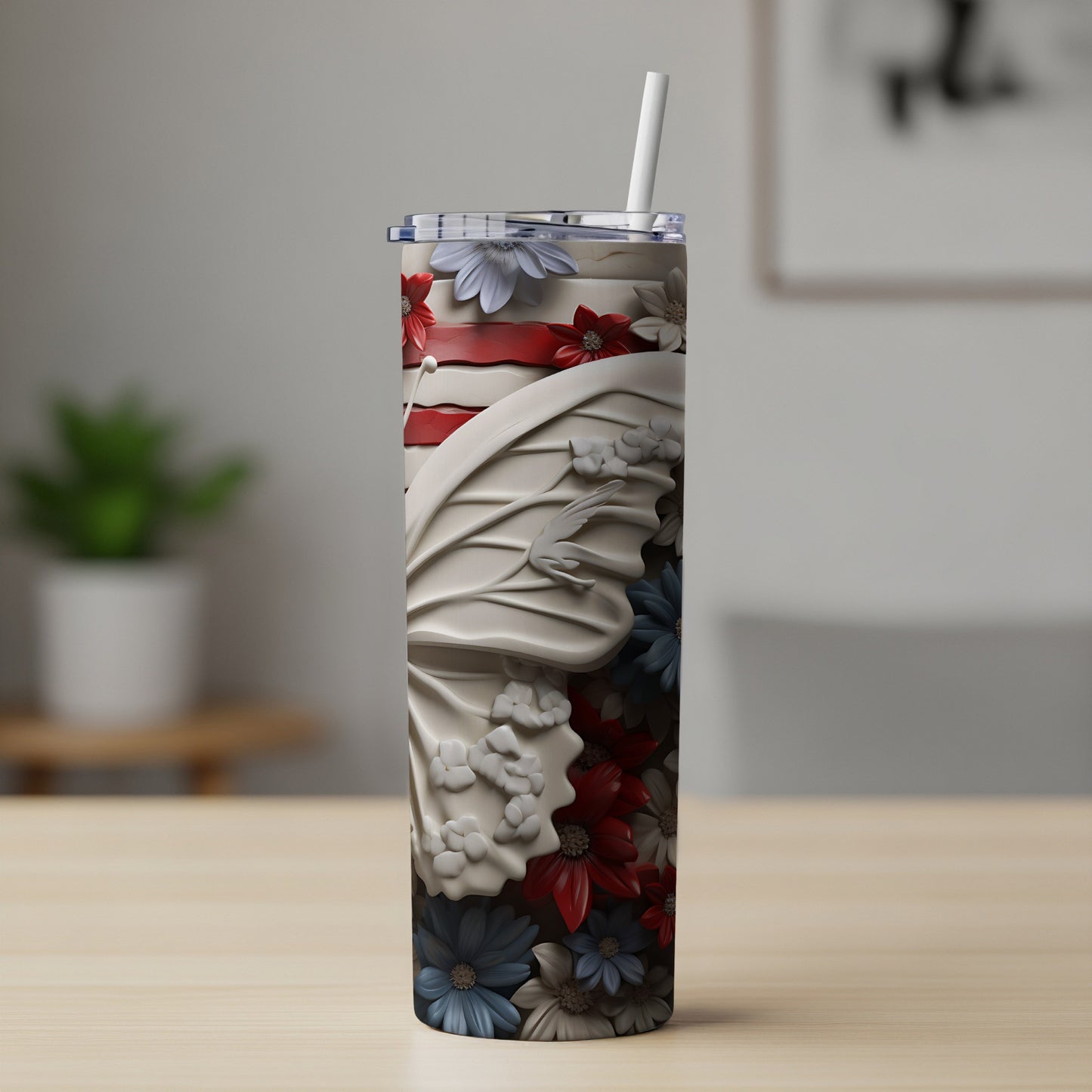White butterfly wings adorned with red, white, and blue flowers on a tumbler.