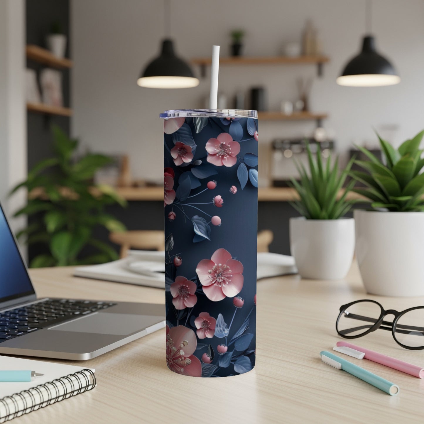Dark blue skinny tumbler with pink floral pattern and white straw.