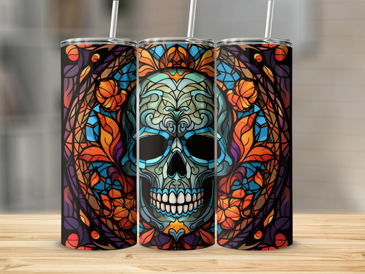 Triptych of colorful stained-glass skull tumblers with straws.