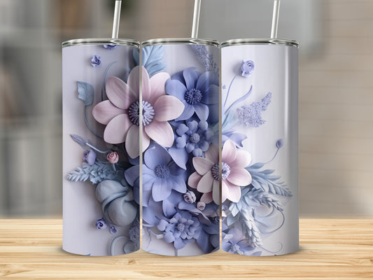 Three pastel floral tumblers with straws arranged on a wooden surface.