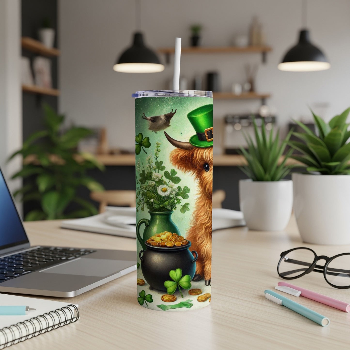 Highland cow in a green hat with shamrocks, gold coins, and a smoothie on a tumbler.