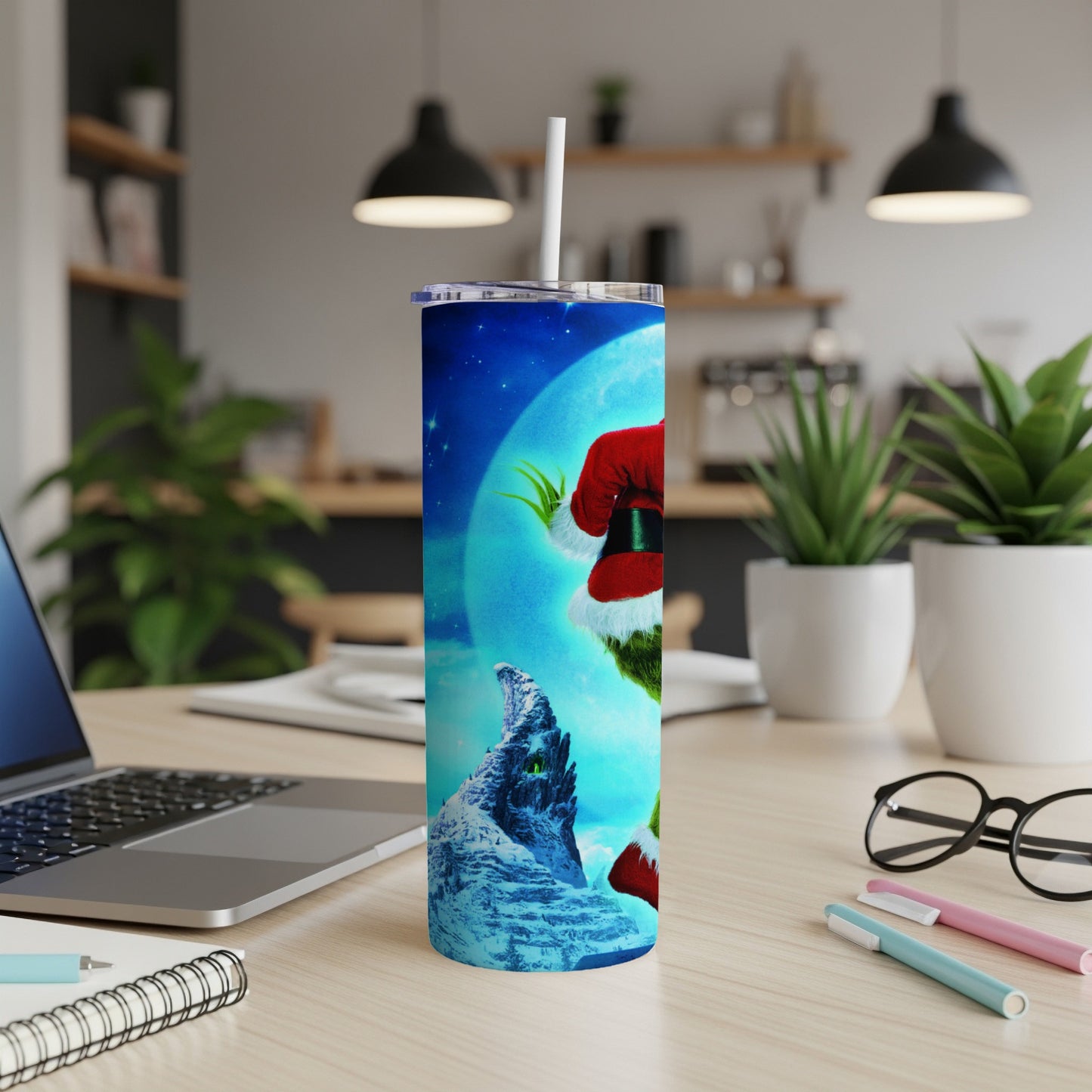 Grinch in Santa hat holding a tumbler with a snowy mountain landscape.