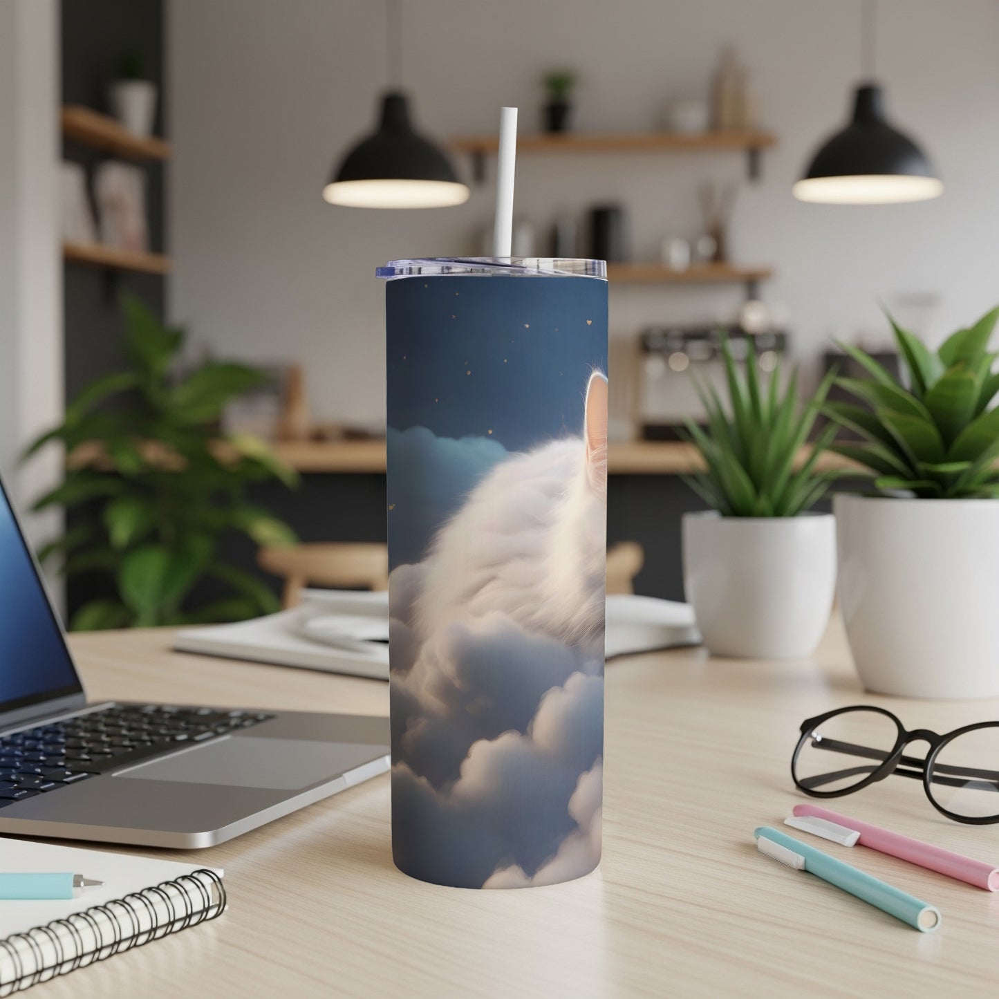 White cat on clouds, on a tumbler with a laptop and pens.