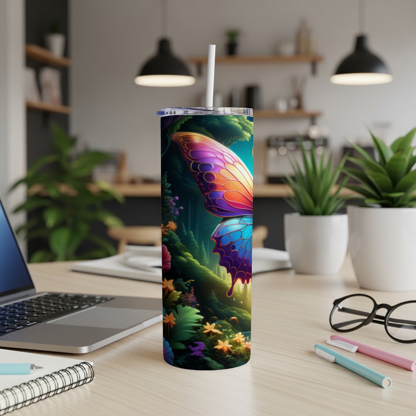 Butterfly art on a tall, skinny tumbler on a desk.