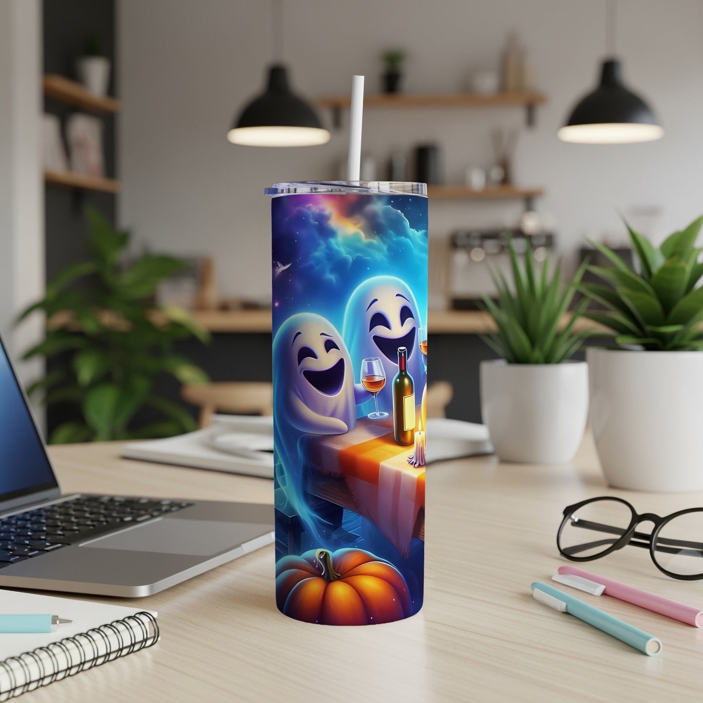 Tumbler with playful ghosts, wine, and pumpkin design on a desk.
