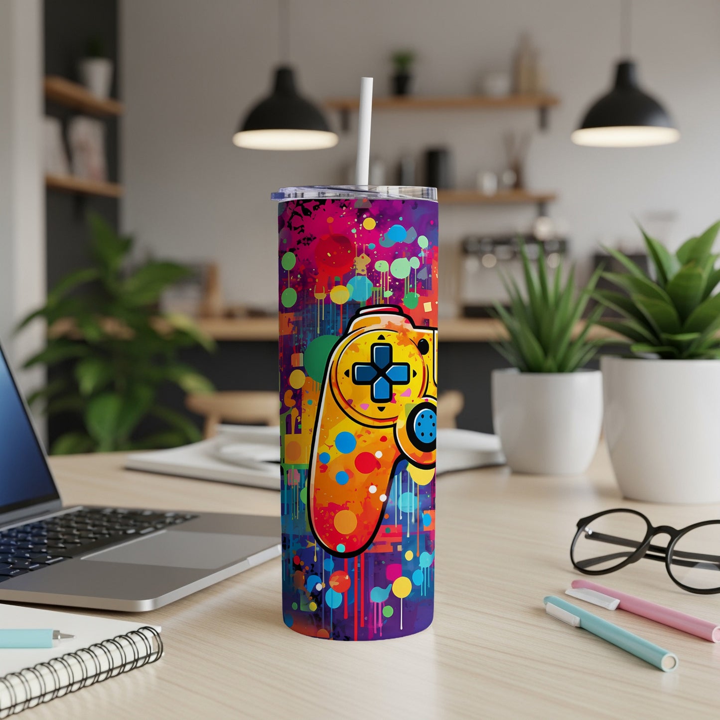 Gamer controller design on a colorful splatter paint tumbler.