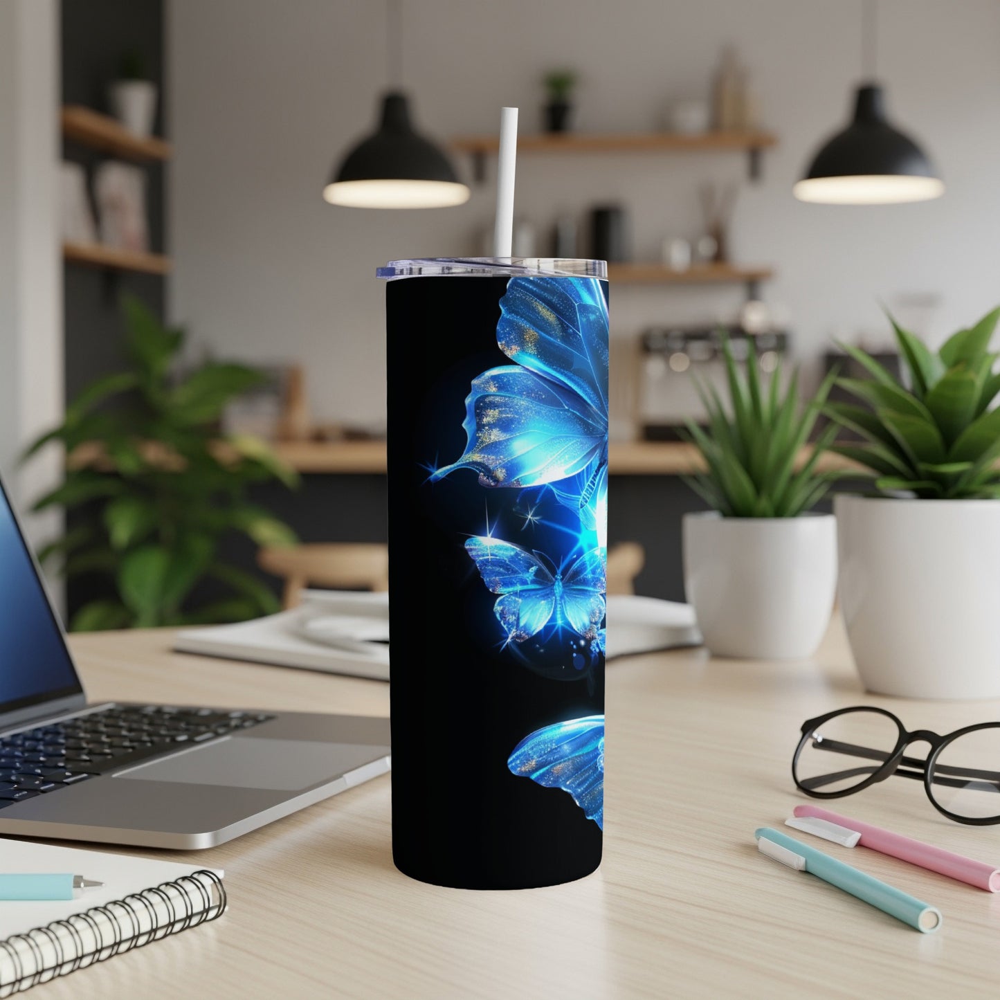 Blue butterflies on a black stainless steel tumbler with a white straw.