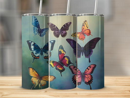 Three tumblers with colorful butterfly designs on a wooden surface.
