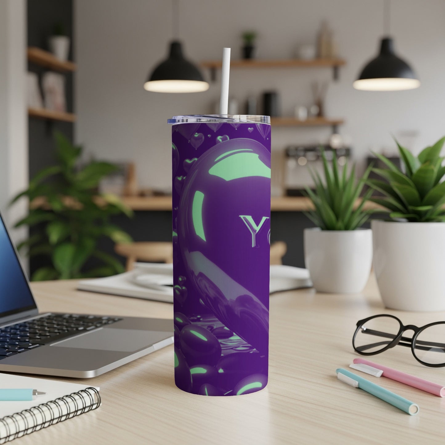 Purple tumbler with "YAH" logo and heart pattern on desk.
